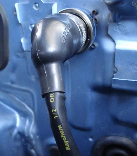 Gaine thermorétractable avec liner adhésif sur un connecteur circulaire — l'étanchéité se joue à cette jonction, pas seulement sur le connecteur lui-même.